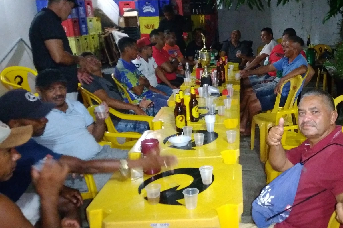 Na-imagem-jogadores-e-torcedores-ao-redor-de-uma-grande-messa-na-festa-de-comemoração-do-título-1ª-Copa-Regional-dos-Quarentões-do-Médio-Parnaíba