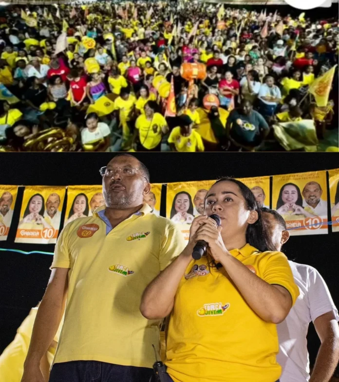 A-imagem-mostra-Gabriela-Nunes-(Republicanos)-e-seu-vice-Afonsinho-(MDB)-abraçados-em-cima-do-palaque-no-último-comício-da-campanha-diante-uma-multidão-de-pessoas-que-lotou-a-Praça-Verônica-Neiva