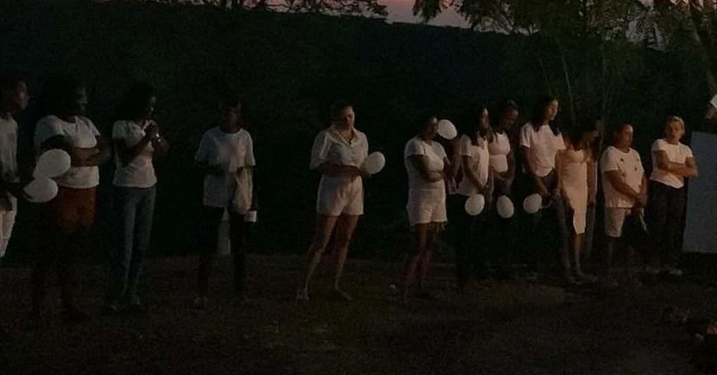 A-foto-mostra-Várias-pessoas-com-balões-brancos-em-oração-por-Lívia-Marques-no-Mirante-do-Morro-da-Cruz.