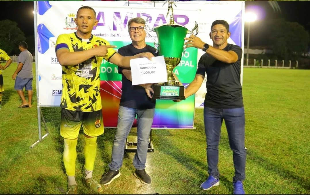 Na-imagem-o-capitão-da-seleção-de-Agricolândia-e-o-secretário-de-esportes-da-cidade-de-camisa-preta-recebem-o-troféu-e-a-premiação-de-5-mil-reais.