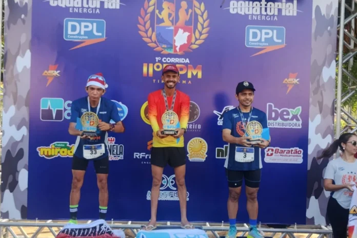 Fabinho-o-fenômeno-do-atletismo-piauiense-atinge-marca-histórica-de-29-vitórias-em-2024-e-se-prepara-para-a-São-Silvestre A-imagem-mostra-Fabinho-levantado-troféu-de-campeão-da-1ª-corrida-do-11º-BPM-da-Polícia-Militar-na-cidade-de-Timon-Maranhão-com-mais-essa-vitória-o-corredor-de-Regeneração-atingiu-marca-histórica-de-29-vitórias-em-2024-e-se-prepara-para-correr-a-São-Silvestre