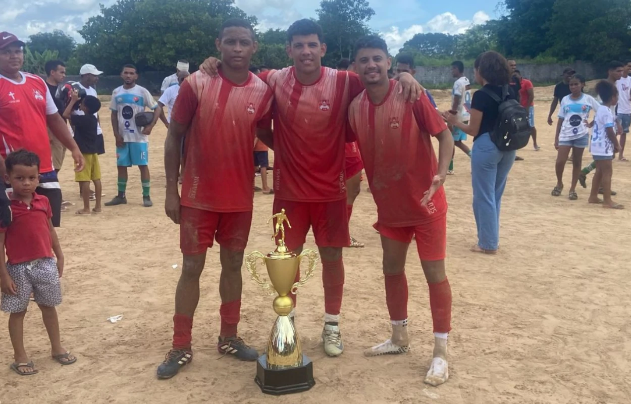 A-imagem-mostra-os-três-jogadores-do-Ajax-naturais-da-cidade-de-Arraial-Caio-Pão-e-Otávio-o-três-posam-com-o-troféu-de-campeão-do-CSU-2025