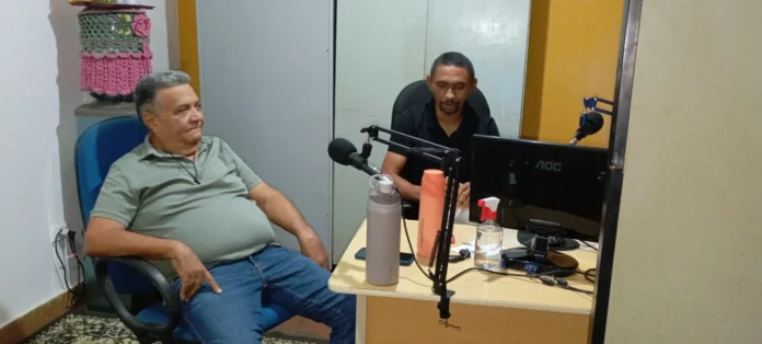 A-foto-mostra-prefeito-Seu-Dua-sentado-diante-do-microfone-da-Rádio-Tribuna-FM-iniciando-sua-entrevista-com-o-radialista-Tarcísio-Silva