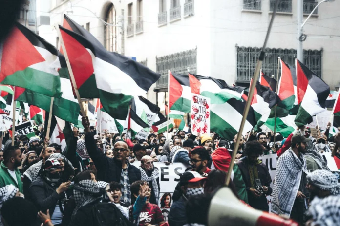 Na-foto-Milhares-de-manifestantes-levantando-bandeiras-Palestinas-pexels-mohammed-abubakr